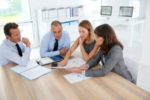 Group of business people meeting around table with tablet